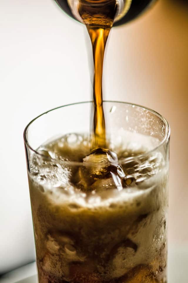 深色飲料倒入裝有冰塊的玻璃杯