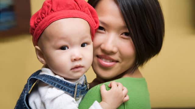 成人懷抱戴紅帽的幼兒