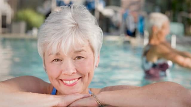 在泳池邊休息的長者