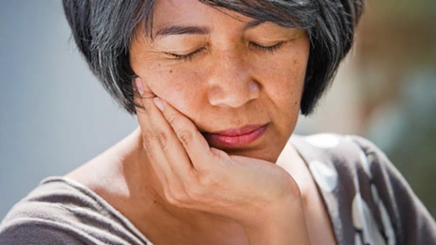 中年人按著臉頰疑似牙痛