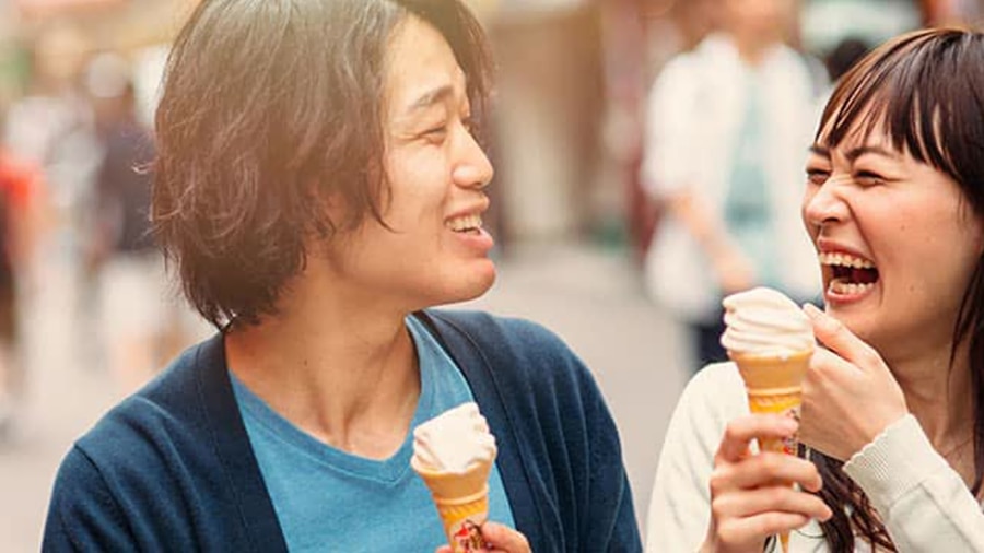 兩人拿著霜淇淋甜筒在街上