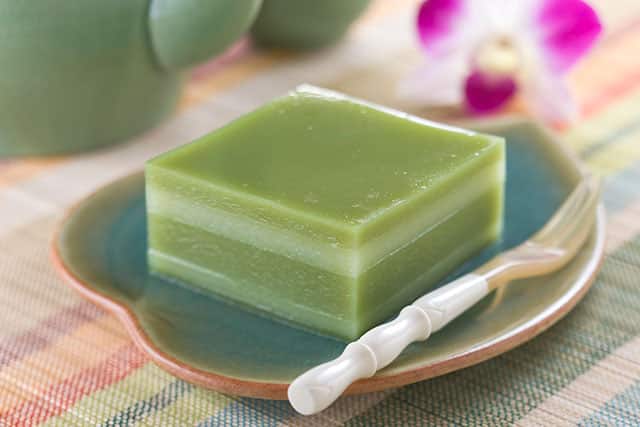 小盤上的綠色分層果凍甜點附小湯匙