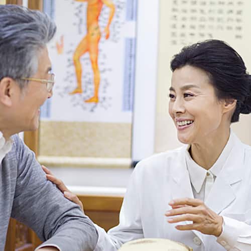 診間醫師與患者交談，背有人體圖