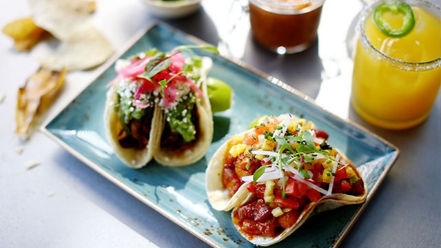 藍色餐盤上的兩個塔可，旁有飲料
