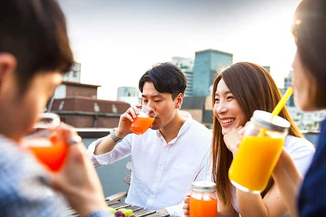 多人在露臺上喝橙色飲料