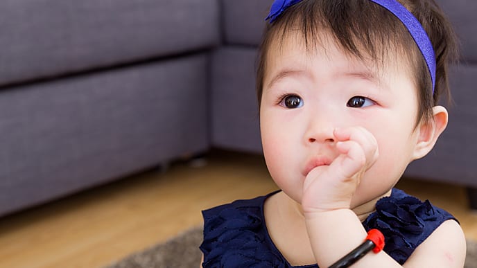 A baby holding a toothbrush while bathing