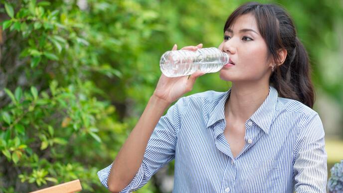 Attractive young woman holding bottle